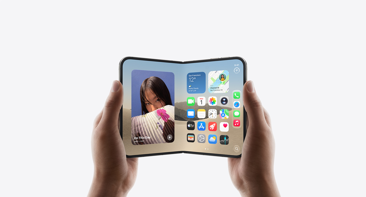 Dvě ruce drží otevřený iPhone Duo na šířku, pohled na vnitřní displej, nebesky bílá barva, na displeji je plocha iOS, vlevo widget fotek, vpravo aplikace