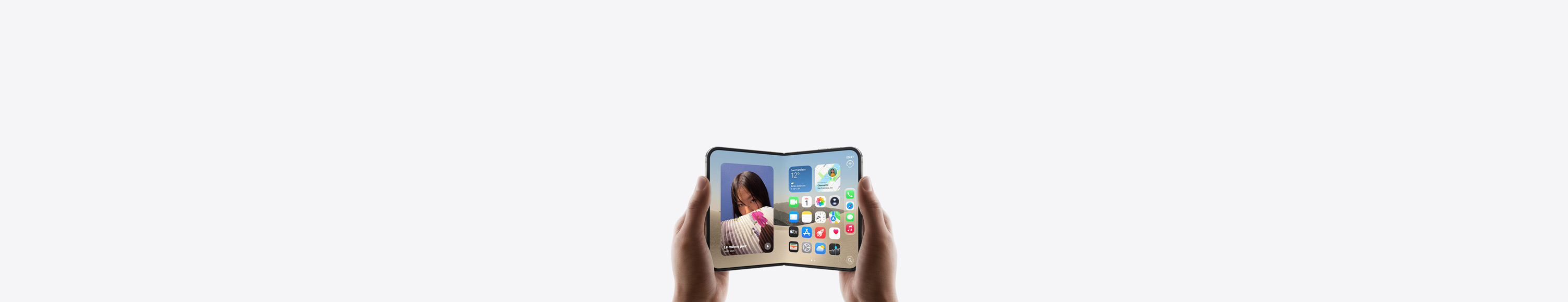 iPhone Duo, tenu par deux mains en mode paysage, déplié, écran interne affichant l’écran d’accueil