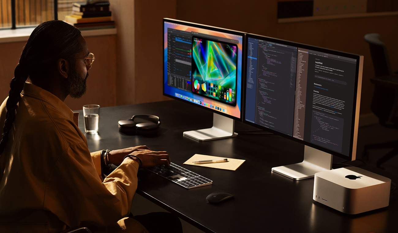 Egy professzionális felhasználó Mac Studión és két Studio Display monitoron dolgozik