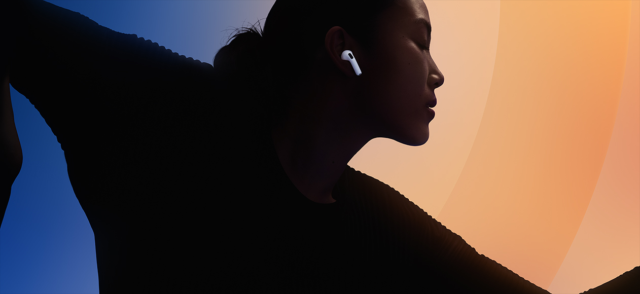 ホワイトのAirPods 5を耳に装着した人物のシルエットが、マルチカラーの背景に浮かんでいる